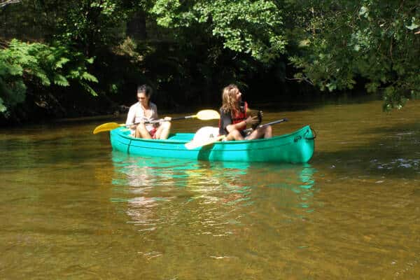 Lou Canoé, deux promeuses observent le paysage naturel sur leur canoé sur la rivière Leyre