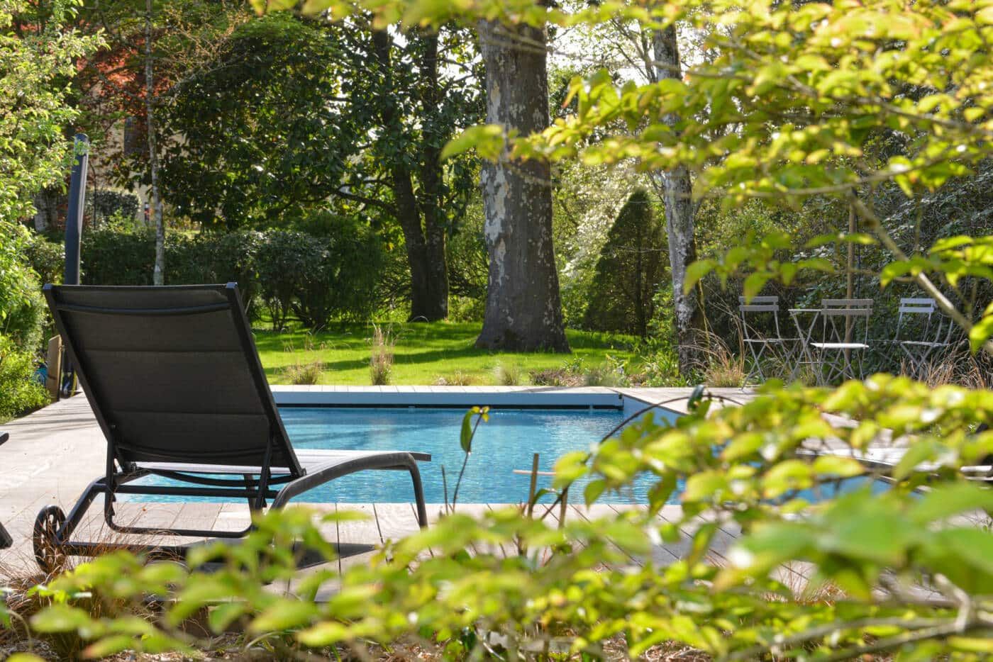 Piscine ombragée et jardin luxuriant à la Maison de Quizas